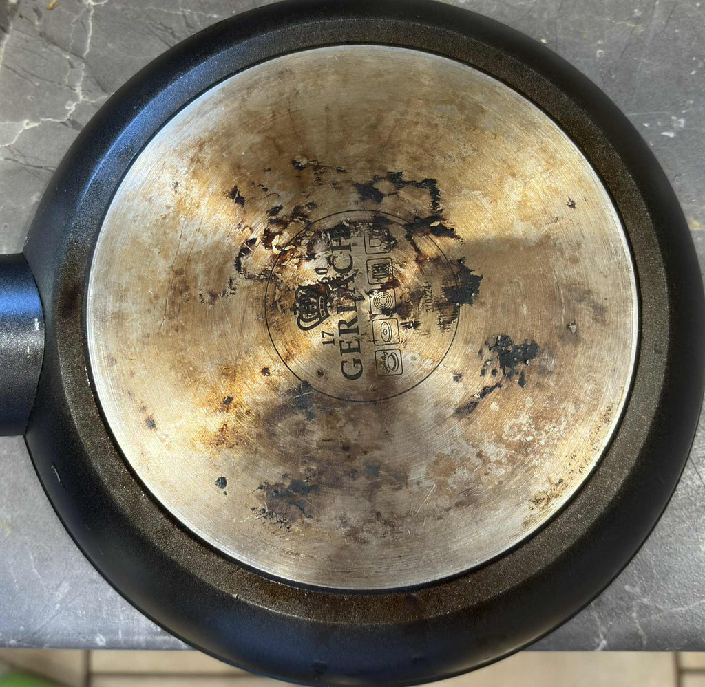 Brudna patelnia przed czyszczeniem - przypalony tłuszcz i osady do usunięcia